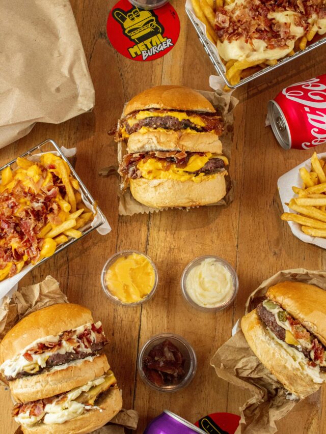 A mouth-watering assortment of burgers and fries arranged on a wooden table, showcasing a classic fast food feast.